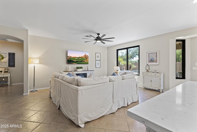 6213 W Gambit Trl, Phoenix, AZ 85083 - living area with light tile patterned floors, a ceiling fan, baseboards, and arched walkways