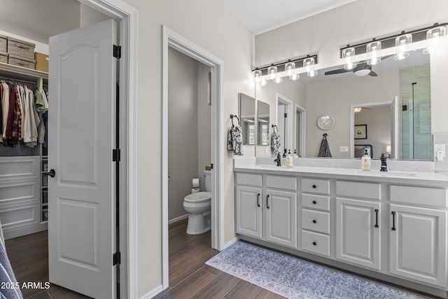 6213 W Gambit Trl, Phoenix, AZ 85083 - bathroom featuring double vanity, toilet, wood finished floors, a spacious closet, and a shower with shower door