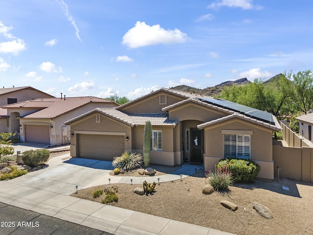6213 W Gambit Trl, Phoenix, AZ 85083 - view of front of home featuring stucco siding, an attached garage, concrete driveway, roof mounted solar panels, and a tiled roof