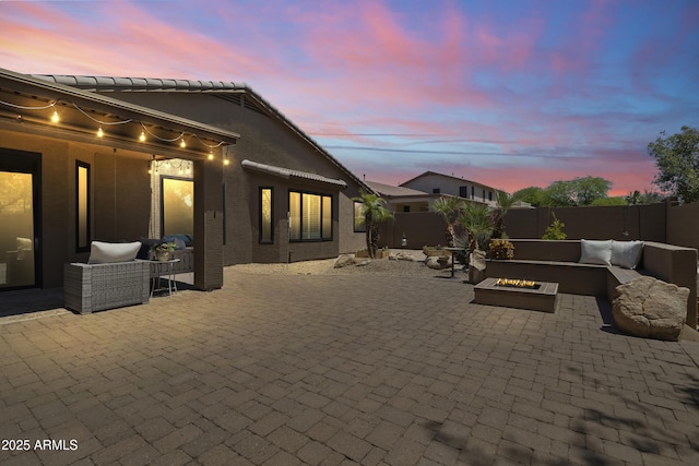 6213 W Gambit Trl, Phoenix, AZ 85083 - patio terrace at dusk featuring a patio, a fenced backyard, and an outdoor living space with a fire pit