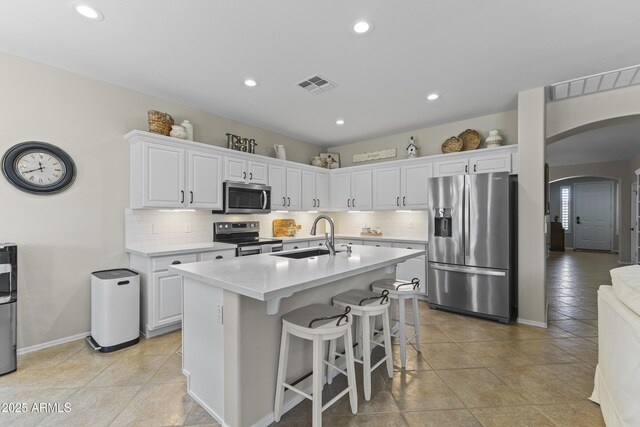 6213 W Gambit Trl, Phoenix, AZ 85083 - kitchen featuring stainless steel appliances, a sink, arched walkways, light countertops, and recessed lighting