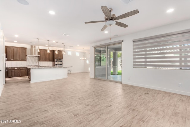 unfurnished living room featuring ceiling fan and light wood-type flooring