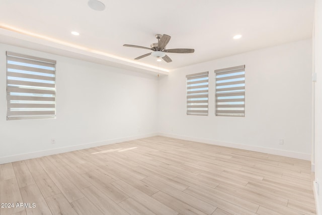 empty room featuring light wood-type flooring, plenty of natural light, and ceiling fan