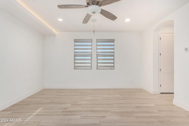 spare room with ceiling fan and light wood-type flooring