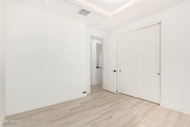 unfurnished bedroom featuring a closet and light hardwood / wood-style floors