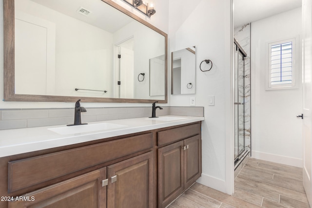 bathroom featuring an enclosed shower, wood-type flooring, backsplash, and vanity