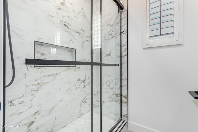 bathroom featuring a shower with shower door