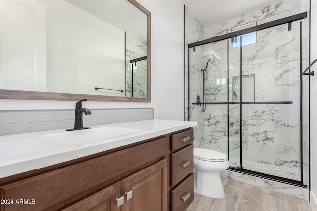 bathroom with hardwood / wood-style flooring, a shower with door, vanity, toilet, and decorative backsplash