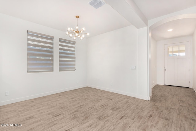 unfurnished room with light hardwood / wood-style floors and a chandelier