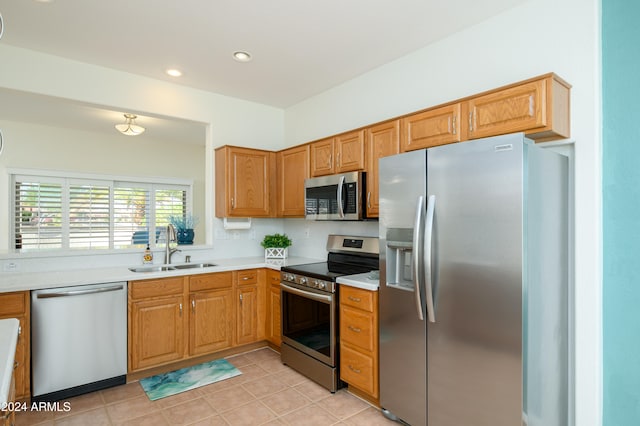 kitchen featuring light tile patterned floors, tasteful backsplash, appliances with stainless steel finishes, and sink