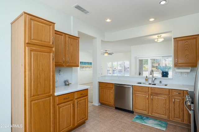 kitchen featuring stainless steel appliances, sink, ceiling fan, light tile patterned floors, and tasteful backsplash