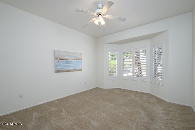 spare room with ceiling fan and light colored carpet