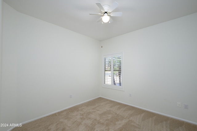 spare room with light colored carpet and ceiling fan