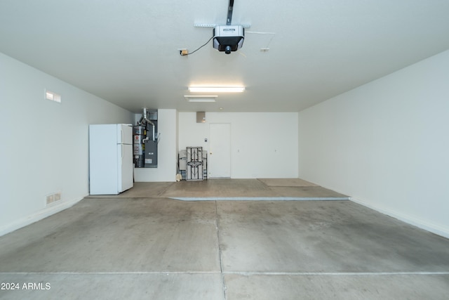 garage featuring a garage door opener, white fridge, and heating unit