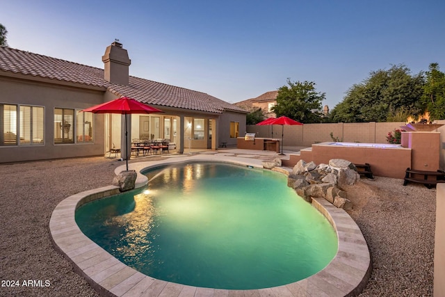 pool at dusk featuring a patio area