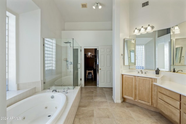 bathroom featuring tile patterned floors, vanity, separate shower and tub, and a high ceiling