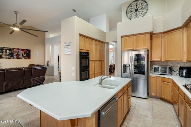 kitchen featuring a center island with sink, sink, stainless steel appliances, and high vaulted ceiling