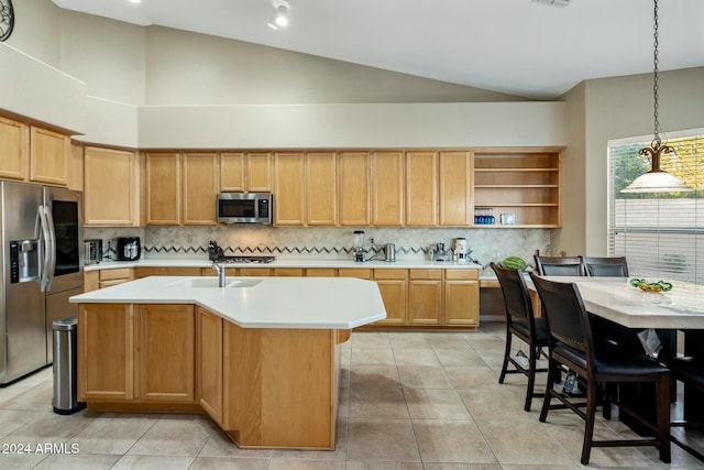 kitchen with stainless steel appliances, sink, an island with sink, hanging light fixtures, and light tile patterned flooring