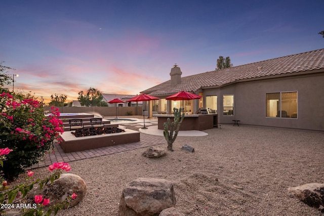 yard at dusk featuring a patio and an outdoor bar