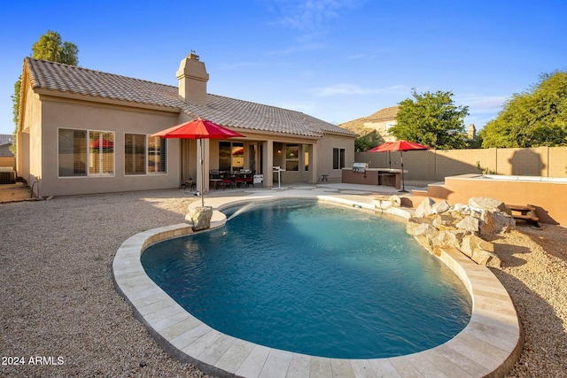 view of swimming pool with an outdoor kitchen, a patio, and central AC