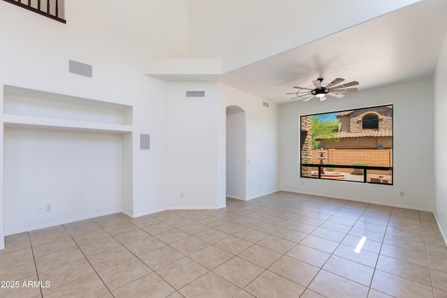 3030 N Saranac, Mesa, AZ 85207 - unfurnished room with arched walkways, light tile patterned floors, ceiling fan, and built in shelves