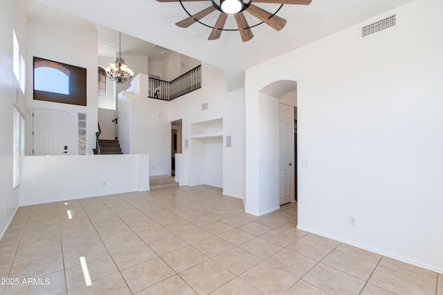 3030 N Saranac, Mesa, AZ 85207 - unfurnished living room featuring a towering ceiling, ceiling fan, arched walkways, light tile patterned floors, and stairway