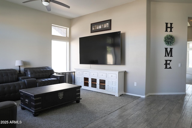 living room featuring ceiling fan and dark hardwood / wood-style floors