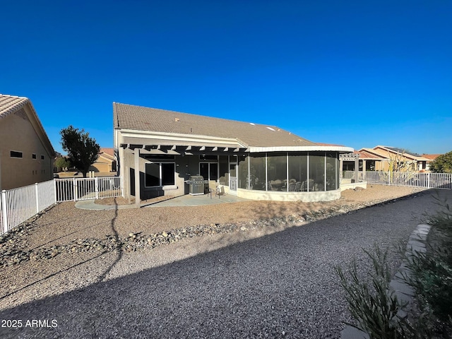 rear view of property with a patio and a sunroom