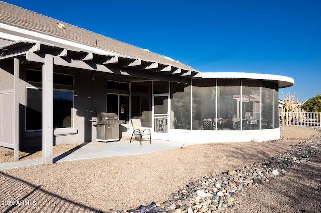 rear view of house with a sunroom and a patio