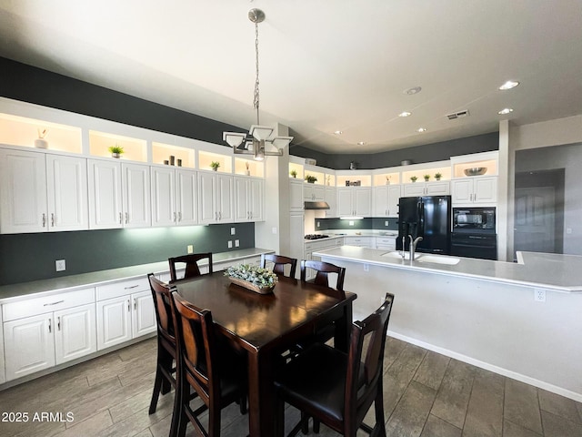 dining room with sink and a notable chandelier