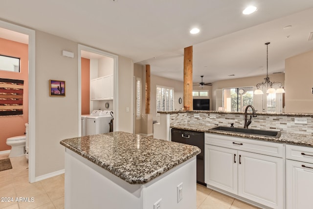 kitchen featuring stone countertops, sink, backsplash, white cabinets, and a center island