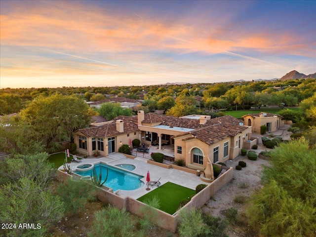 pool at dusk featuring a patio area