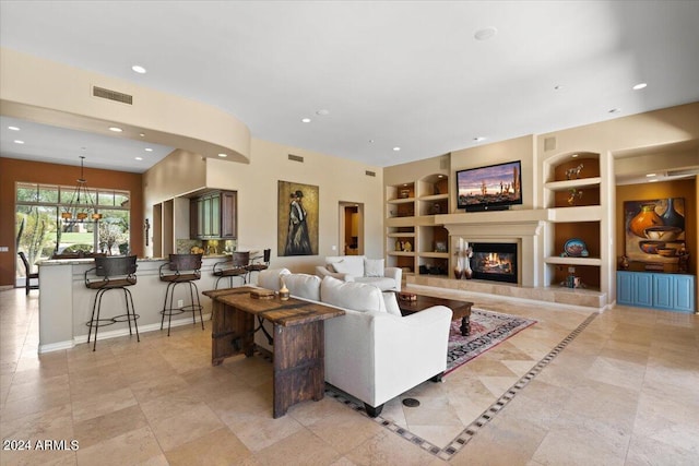 tiled living room featuring built in features and an inviting chandelier