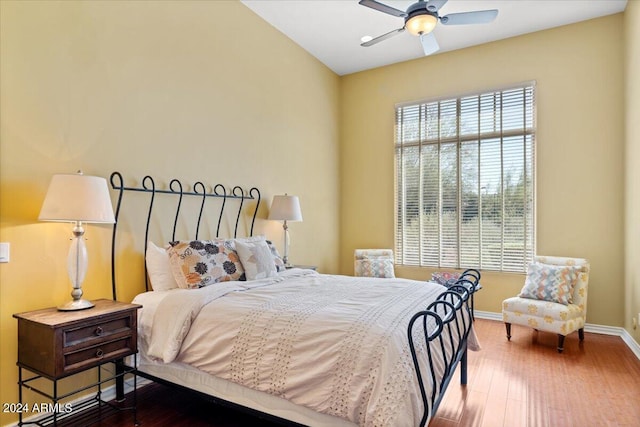 bedroom with ceiling fan, wood-type flooring, and vaulted ceiling