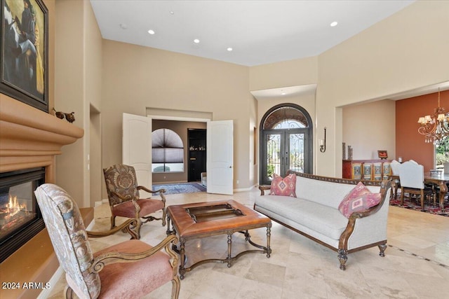 living room with light tile patterned floors, a high ceiling, and an inviting chandelier