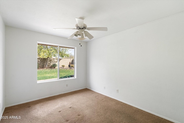 spare room with baseboards, ceiling fan, and carpet flooring