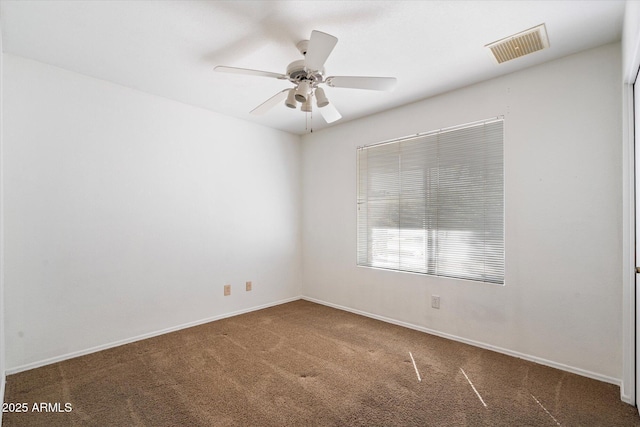 spare room featuring baseboards, visible vents, carpet floors, and ceiling fan