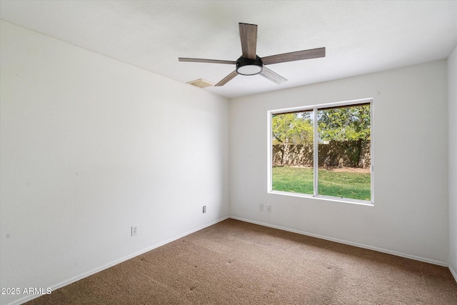 empty room featuring visible vents, carpet floors, baseboards, and a ceiling fan