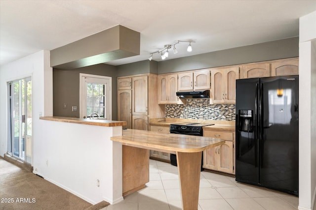 kitchen with backsplash, wooden counters, light brown cabinetry, under cabinet range hood, and black appliances