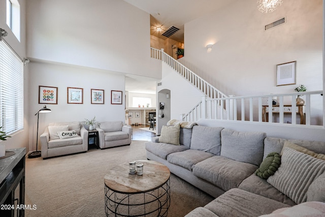 carpeted living room featuring a towering ceiling