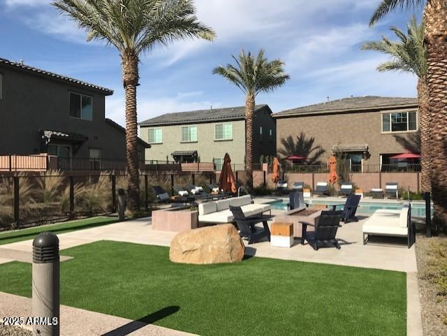 view of community featuring a patio area, a yard, a pool, and fence