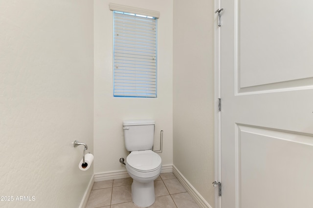 bathroom featuring tile patterned flooring, toilet, and baseboards