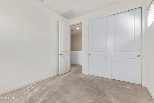 unfurnished bedroom featuring visible vents, baseboards, carpet, and a closet