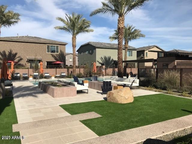 view of property's community featuring a residential view, a lawn, and fence