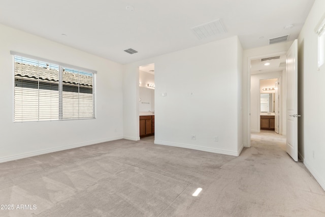 unfurnished bedroom featuring visible vents, light carpet, and baseboards