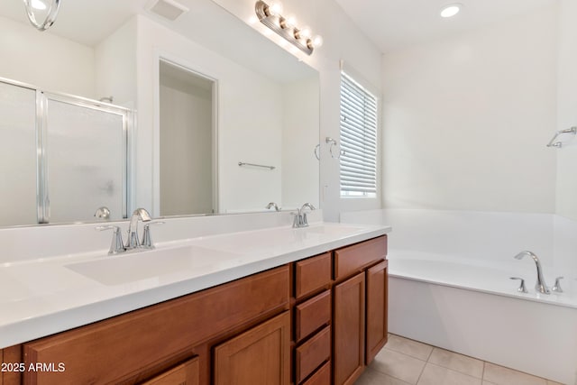 bathroom with tile patterned floors, a stall shower, a garden tub, and a sink