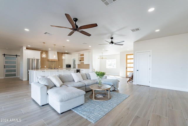 3909 S Veronica Ln, Gold Canyon, AZ 85118 - living room featuring baseboards, a barn door, visible vents, ceiling fan, and light wood finished floors
