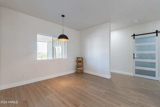 3909 S Veronica Ln, Gold Canyon, AZ 85118 - empty room with light wood-style flooring, baseboards, and a barn door