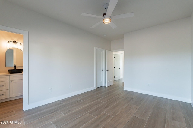 3909 S Veronica Ln, Gold Canyon, AZ 85118 - unfurnished bedroom featuring ceiling fan, light wood-style flooring, ensuite bath, a sink, and baseboards