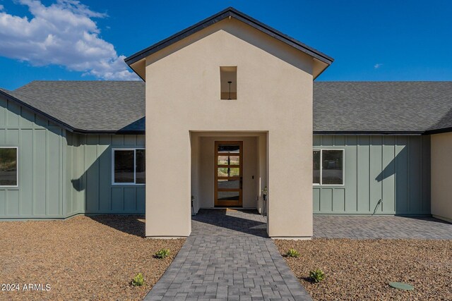 3909 S Veronica Ln, Gold Canyon, AZ 85118 - doorway to property with roof with shingles, board and batten siding, and a patio area